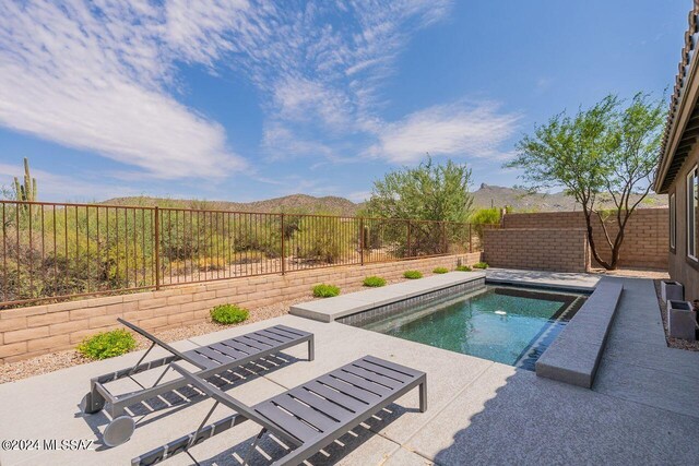 view of pool featuring a patio area, a mountain view, and a hot tub