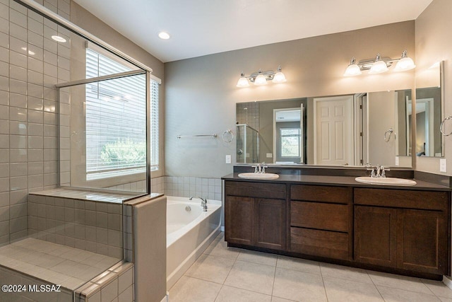 full bathroom with a bath, a sink, a stall shower, and tile patterned floors