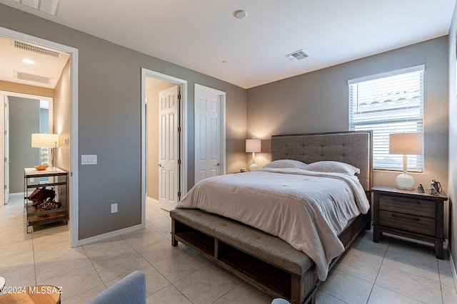 bedroom with light tile patterned flooring, baseboards, and visible vents