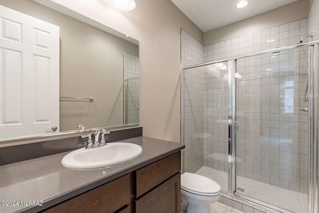 full bath featuring a stall shower, toilet, and vanity