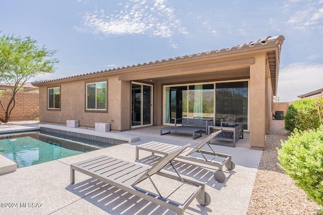 rear view of property with a patio area, fence, a fenced in pool, and stucco siding