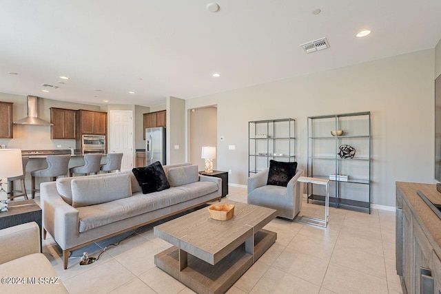 living area with light tile patterned floors, baseboards, visible vents, and recessed lighting