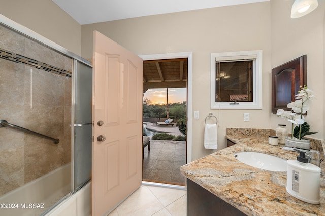 bathroom featuring tile patterned flooring, vanity, and enclosed tub / shower combo