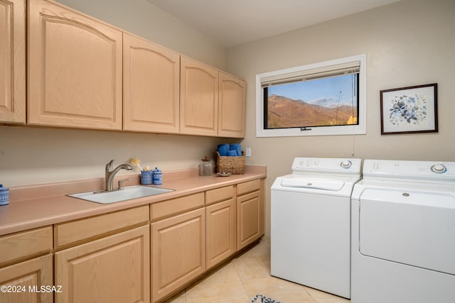 washroom featuring cabinets, sink, washing machine and dryer, and light tile patterned flooring