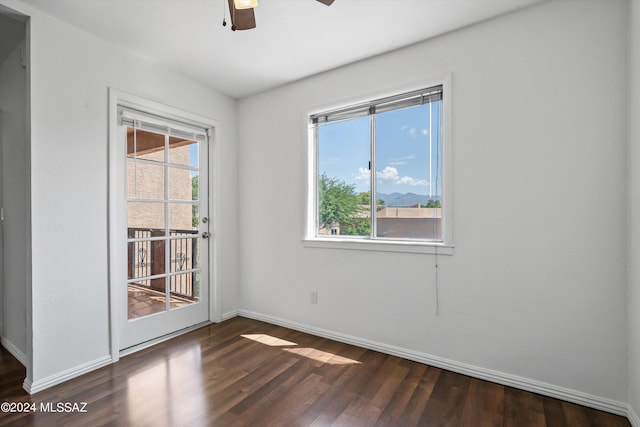 spare room with ceiling fan, dark wood-type flooring, and a healthy amount of sunlight