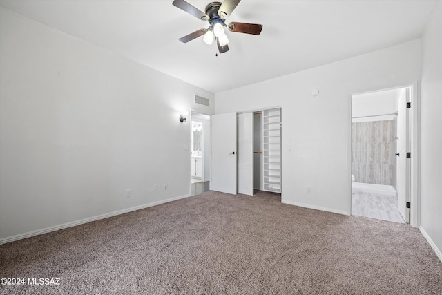 unfurnished bedroom with ensuite bathroom, carpet flooring, ceiling fan, and a closet