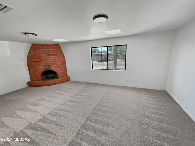 unfurnished living room with light carpet and a fireplace