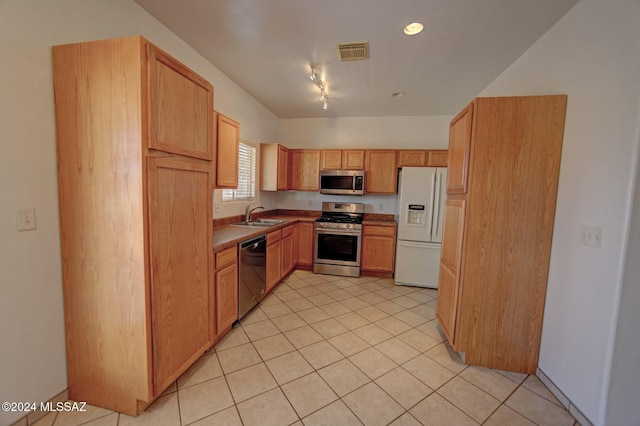 kitchen with light tile patterned floors, rail lighting, stainless steel appliances, and sink