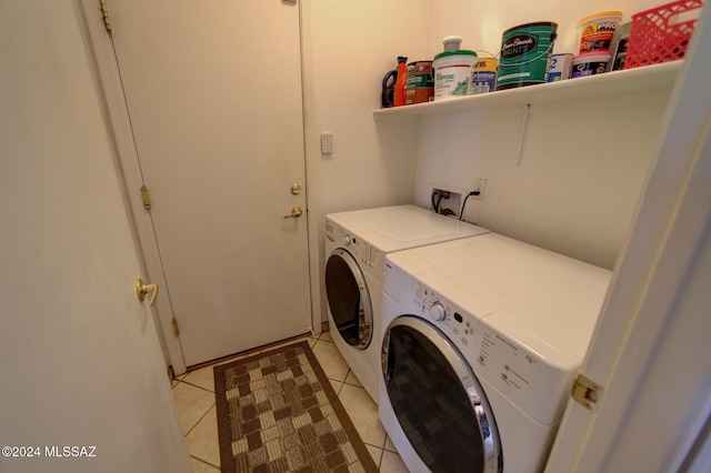 laundry area with washing machine and clothes dryer and light tile patterned floors