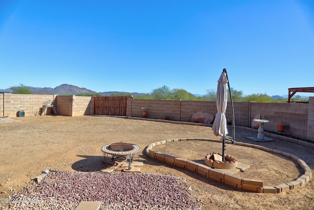 view of yard with a mountain view and an outdoor fire pit