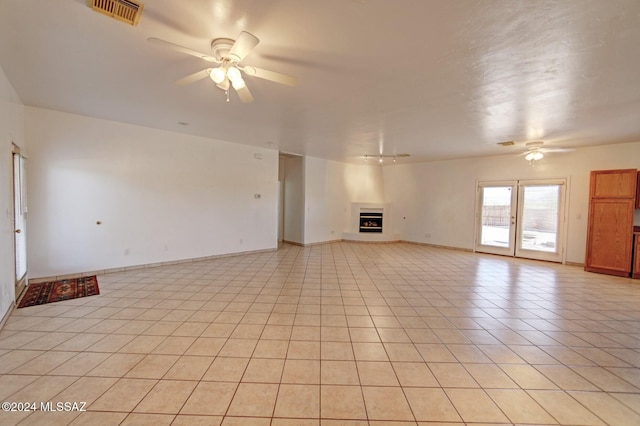 unfurnished living room featuring ceiling fan and light tile patterned floors