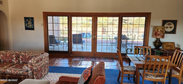 doorway with tile patterned floors, visible vents, plenty of natural light, and arched walkways