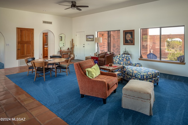 living room featuring dark tile patterned floors and ceiling fan