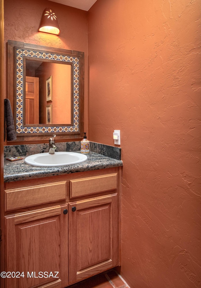 bathroom featuring vanity and a textured wall