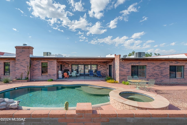 pool featuring central AC unit, an in ground hot tub, and a patio