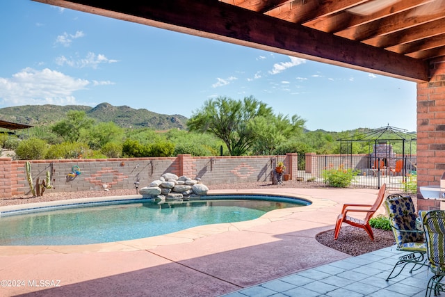 view of swimming pool with a mountain view and a patio area