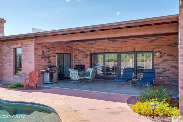 view of patio / terrace with area for grilling and an outdoor pool