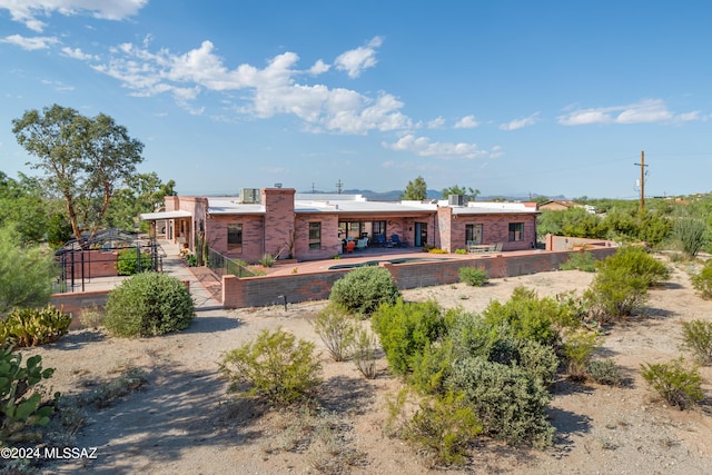 rear view of property with a patio area and brick siding