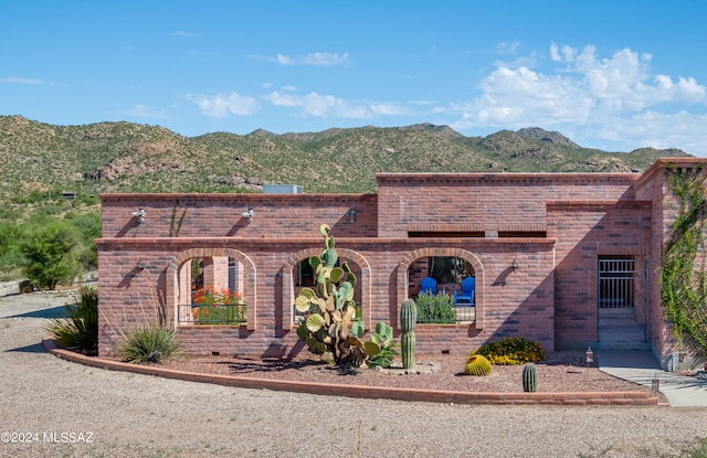 view of front of house featuring brick siding and a mountain view