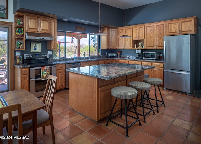 kitchen featuring open shelves, under cabinet range hood, a center island, appliances with stainless steel finishes, and tile patterned flooring