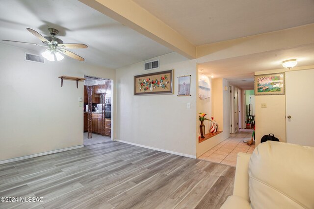 living room featuring beamed ceiling, tile patterned floors, and ceiling fan