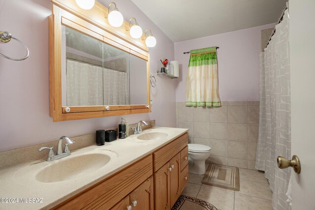 bathroom with dual vanity, tile walls, toilet, and tile patterned flooring