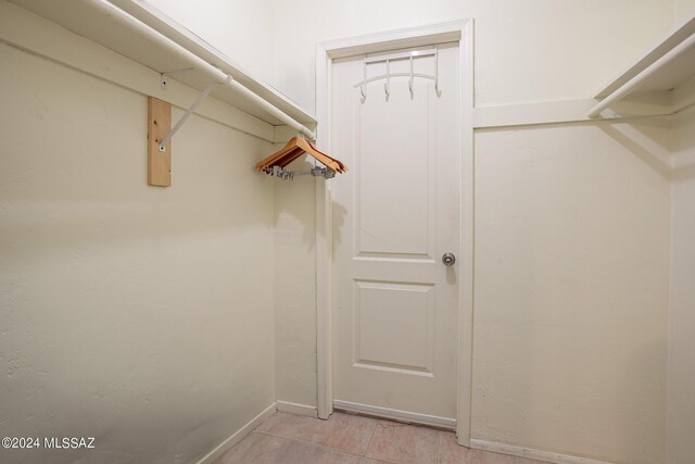 spacious closet with light tile patterned floors