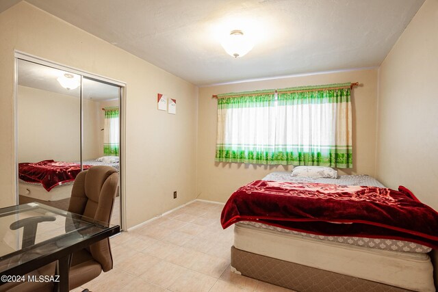 bedroom with light tile patterned flooring and a closet