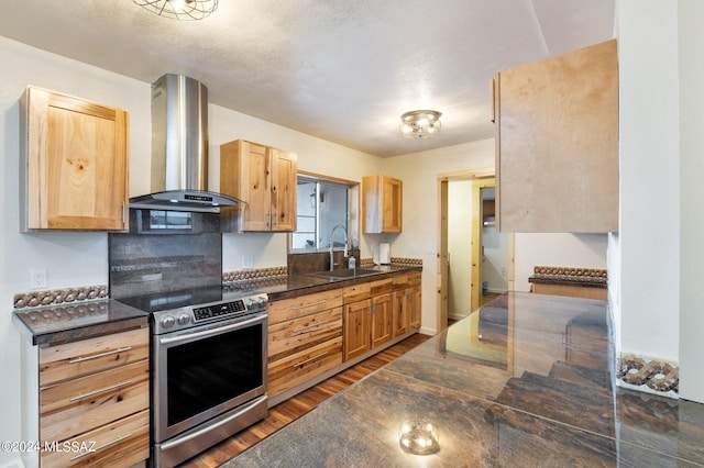 kitchen featuring light brown cabinets, wall chimney range hood, dark wood-type flooring, stainless steel range with electric cooktop, and sink