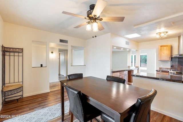 dining room with ceiling fan and dark hardwood / wood-style floors