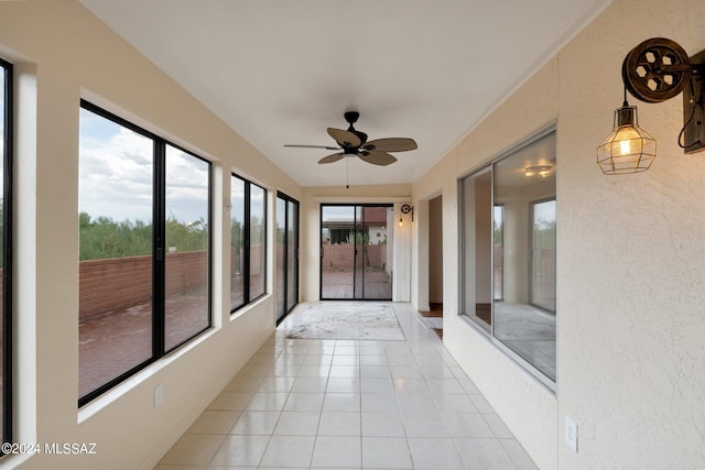 unfurnished sunroom featuring ceiling fan