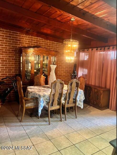 tiled dining area featuring beamed ceiling, a notable chandelier, brick wall, and wood ceiling