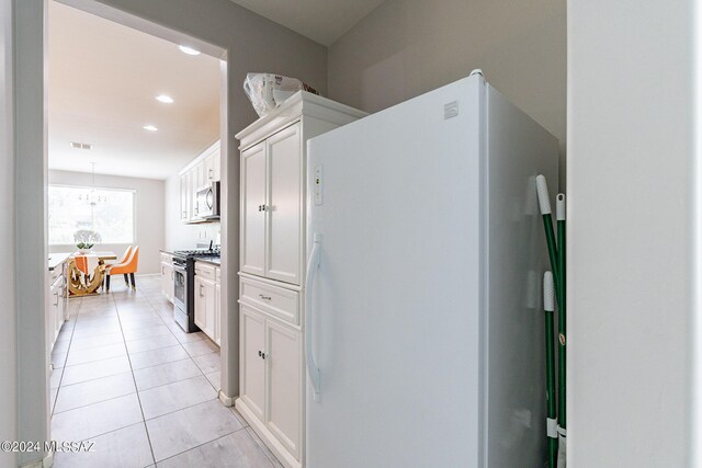 kitchen with light tile patterned flooring, pendant lighting, stainless steel appliances, and white cabinets