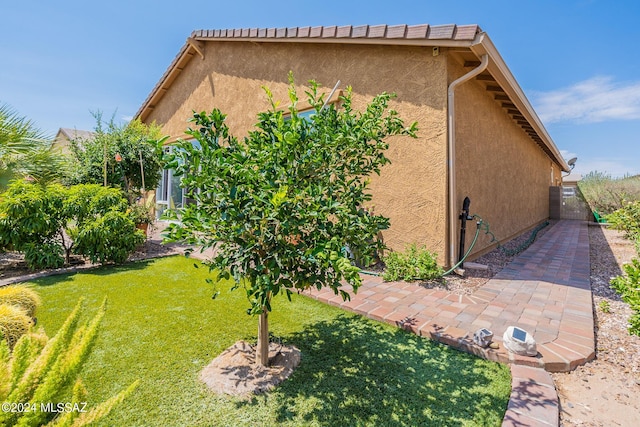 view of home's exterior featuring a lawn and a patio area