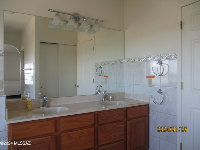 bathroom featuring dual vanity and tile walls