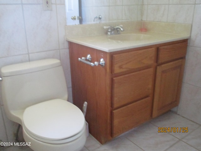 bathroom with vanity, toilet, tile patterned floors, and tile walls