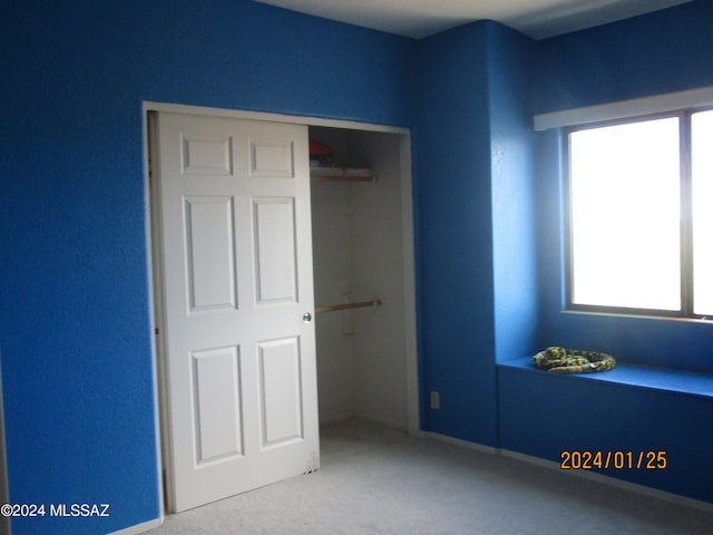 unfurnished bedroom with a closet and carpet floors