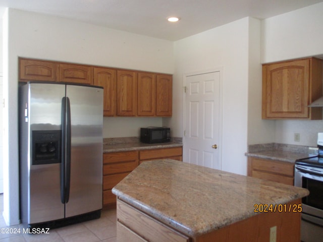 kitchen featuring appliances with stainless steel finishes, light tile patterned flooring, and light stone countertops