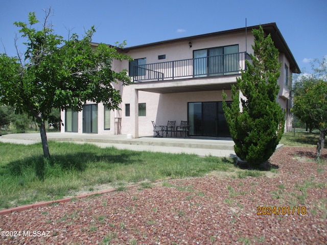 back of house featuring a balcony and a patio area