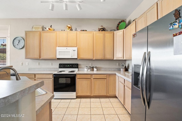 kitchen with white appliances, light brown cabinetry, sink, and light tile patterned floors