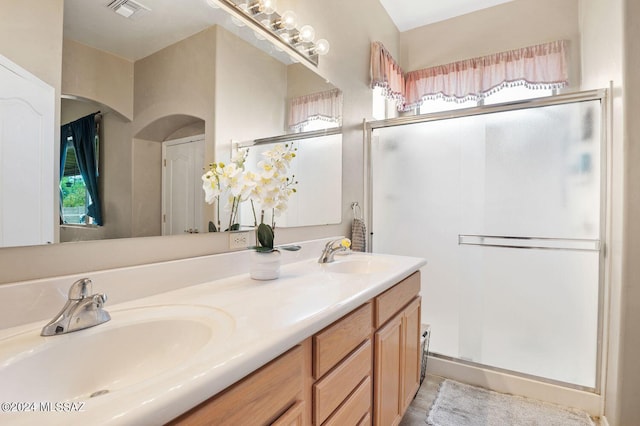 bathroom with walk in shower and vanity