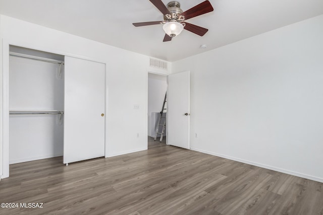 unfurnished bedroom with a closet, hardwood / wood-style floors, and ceiling fan