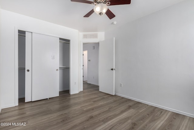 unfurnished bedroom with ceiling fan, hardwood / wood-style flooring, and a closet