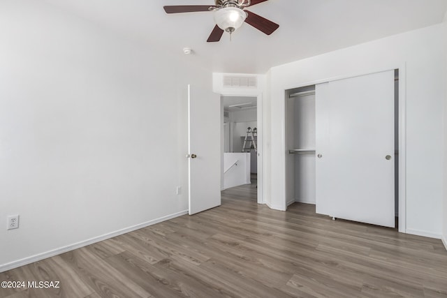 unfurnished bedroom with hardwood / wood-style flooring, a closet, and ceiling fan