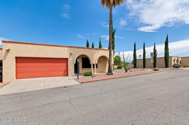 view of front of home with driveway, an attached garage, and stucco siding