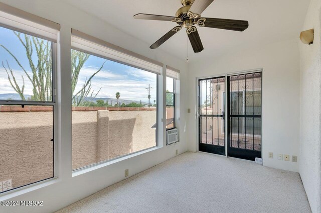 unfurnished sunroom featuring ceiling fan and a healthy amount of sunlight