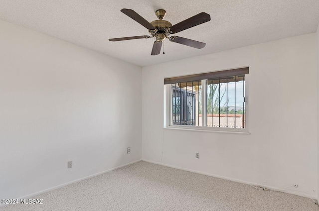 carpeted spare room featuring ceiling fan, a textured ceiling, and baseboards