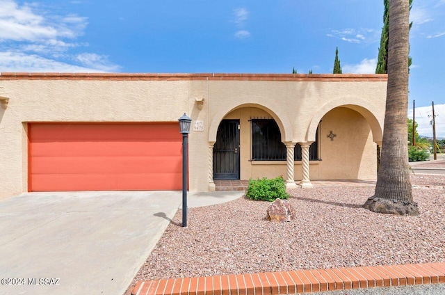 mediterranean / spanish home with a garage, driveway, and stucco siding