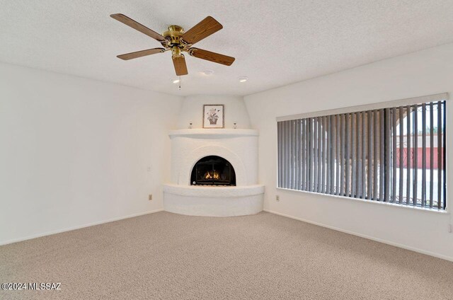 unfurnished living room with ceiling fan, carpet, and a textured ceiling