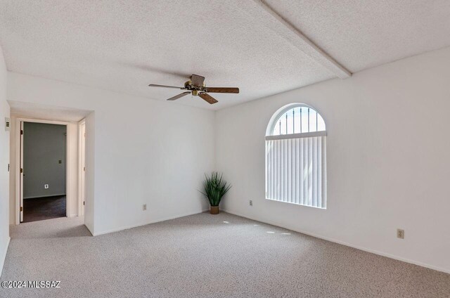 carpeted empty room with ceiling fan and a textured ceiling